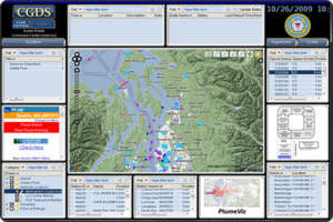 Screenshot of the Coast Guard Dashboard System that consists of a center map of the Puget Sound, Washington, area overlayed with vessel icons. The map is surrounded by numerous dashboard components providing various modeling data and information.